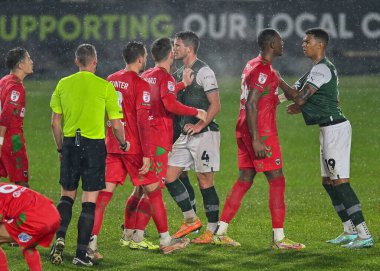 Plymouth Argyle forvet Morgan Whittaker (19) ve AFC Wimbledon defans oyuncusu Luke Jenkins (36) arasındaki Melee Papa John 's Trophy karşılaşmasında Plymouth Argyle AFC Wimbledon' a karşı Home Park, Plymouth, İngiltere, 21 Aralık 202