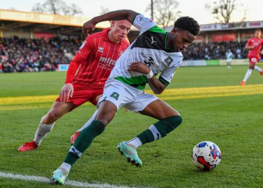 Plymouth Argyle tam saha Bali Mumba (17), Cheltenham Town orta saha oyuncusu Ryan Broom (32) ile Cheltenham Town - Plymouth Argyle maçında topu Birleşik Krallık 'ın başkenti Cheltenham' da bulunan Jonny-Rocks Stadyumu 'nda koruyor.
