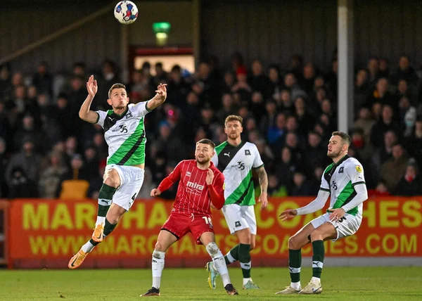 Plymouth Argyle orta saha oyuncusu Jordan Houghton (4), Cheltenham Town - Plymouth Argyle maçında Birleşik Krallık 'ın Jonny-Rocks Stadyumu, Cheltenham' da 26 Aralık 202 'de oynanan karşılaşmada havada mücadele etti.
