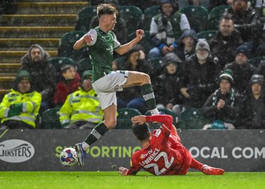 Milton Keynes Dons defans oyuncusu Henry Lawrence (22), Plymouth Argyle orta saha oyuncusu Jack Endacott (42) ile oynadığı Sky Bet 1 karşılaşmasında topu Home Park, Plymouth, Birleşik Krallık 1 Ocak 202 'de MK Dons maçında kazandı.
