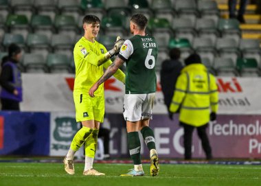 Plymouth Argyle kalecisi Michael Cooper (1) ve Plymouth Argyle defans oyuncusu Dan Scarr (6), 1 Ocak 202 'de Home Park, Plymouth, İngiltere' de oynanan Sky Bet 1 karşılaşmasında kazandıkları galibiyeti kutladılar.