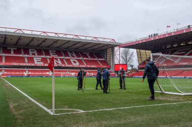 Nottingham Forest groundsmen tend to the pitch after heavy rainfall ahead of the Premier League match Nottingham Forest vs Leicester City at City Ground, Nottingham, United Kingdom, 14th January 202