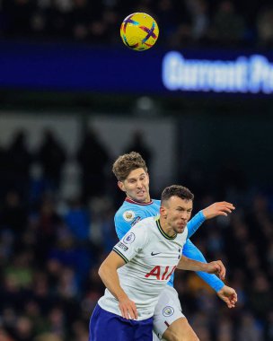 John Stones #5 of Manchester City and Ivan Perii #14 of Tottenham Hotspur battle for the ball during the Premier League match Manchester City vs Tottenham Hotspur at Etihad Stadium, Manchester, United Kingdom, 19th January 2023