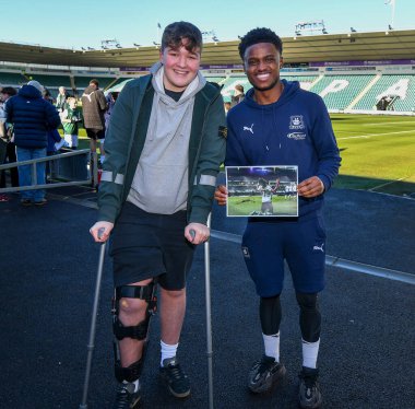 Plymouth Argyle full back Bali Mumba  (17)  sign the picture for a young fan who broke his knee celebrating Plymouth Argyle full back Bali Mumba  (17)  goal in Ipswich Town  during the Sky Bet League 1 match Plymouth Argyle vs Cheltenham Town at Home