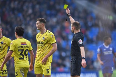 referee , Leigh Doughty,  issues Jake Cooper #5 of Millwall  a yellow card during the Sky Bet Championship match Cardiff City vs Millwall at Cardiff City Stadium, Cardiff, United Kingdom, 21st January 202