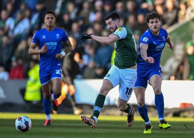 Plymouth Argyle midfielder Finn Azaz (18) passes the ball forward while under pressure from Cheltenham Town defender Charlie Raglan  (5)  during the Sky Bet League 1 match Plymouth Argyle vs Cheltenham Town at Home Park, Plymouth, United Kingdom, 21s