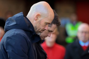 Team manager Erik ten Hag and Womens team manager Mark Skinner bow their heads as Manchester United mark the 65th anniversary of the Munich Air Disaster at Old Trafford, Manchester, United Kingdom, 6th February 2023