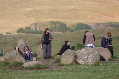 İnsanlar Castlerigg Taş Çemberi Yaz Gündönümü Kutlaması 'nda güneşin batmaya başladığı sırada toplanıyor.