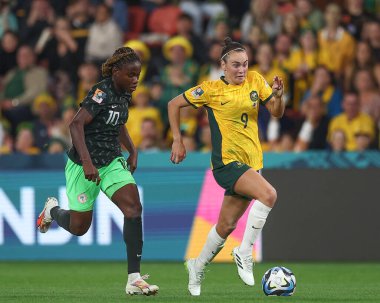 Avustralyalı 9. Caitlin Foord, 27 Temmuz 2023 tarihinde Brisbane, Avustralya 'daki Suncorp Stadyumu' nda oynanan FIFA Kadınlar Dünya Kupası 2023 Grubu B Grubu karşılaşmasında Christy Ucheibe # 10 numaralı Nijerya baskısı sırasında topa vuruyor.
