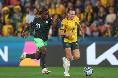 Avustralyalı 9. Caitlin Foord, 27 Temmuz 2023 tarihinde Brisbane, Avustralya 'daki Suncorp Stadyumu' nda oynanan FIFA Kadınlar Dünya Kupası 2023 Grubu B Grubu karşılaşmasında Christy Ucheibe # 10 numaralı Nijerya baskısı sırasında topa vuruyor.