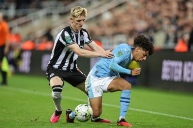 Manchester City 'nin 82 numaralı oyuncusu Rico Lewis, Newcastle City' nin 27 Eylül 202 'de St. James' s Park 'ta oynanan Carabao Cup Üçüncü Raund karşılaşmasında Newcastle United' ın Anthony Gordon # 10 'u Newcastle United' ın attığı top ile kayıyor.