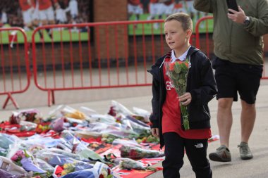 Genç bir hayran merhum Sir Bobby Charlton 'a saygılarını sunmak için 23 Ekim 2023' te Old Trafford, Manchester, İngiltere 'nin dışında çiçek getirdi.