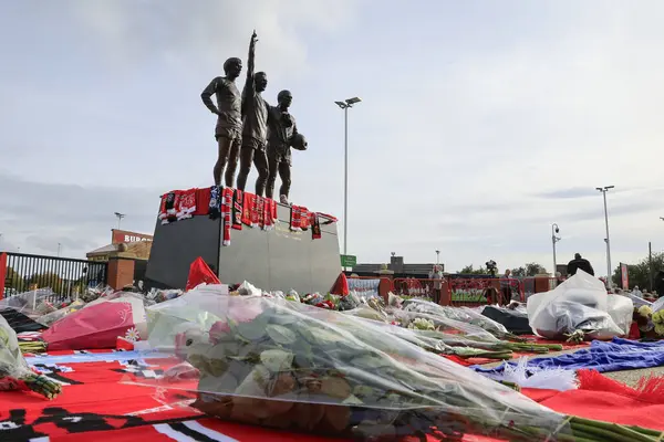 stock image Floral arrangements at the Trinity statue in tribute to the late Sir Bobby Charlton outside of Old Trafford, Manchester, United Kingdom, 23rd October 2023