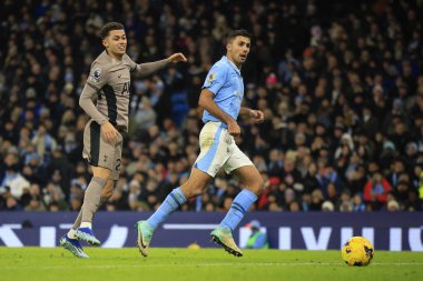 Manchester City 'den 16 numaralı Rodrigo, Premier League maçında Brennan Johnson # 22 Tottenham Hotspur' un izlediği topu geçiyor Manchester City - Tottenham Hotspur maçı sırasında Etihad Stadyumu, Manchester, İngiltere, 3 Aralık 2023