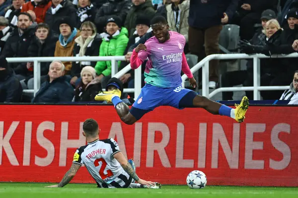 stock image Yunus Musah #80 of AC Milan is slide tackled by Kieran Trippier #2 of Newcastle United during the UEFA Champions League match Newcastle United vs AC Milan at St. James's Park, Newcastle, United Kingdom, 13th December 2023