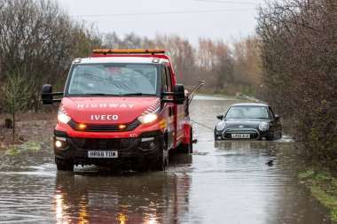 Newton Lane, Fairburn, Castleford, İngiltere, 2 Ocak 2023 'te Leeds yakınlarında fırtınalar ve sağanak yağış nedeniyle sel basmış yolda kalmış bir aracı otoyola çekiyor.