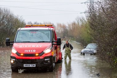 Newton Lane, Fairburn, Castleford, İngiltere, 2 Ocak 2023 'te Leeds yakınlarında fırtınalar ve sağanak yağış nedeniyle sel basmış yolda kalmış bir aracı otoyola çekiyor.