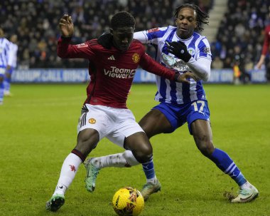 Wigan Athletic 'ten Martial Godo, 8 Ocak 202' de Wigan, İngiltere 'de bulunan Wigan Stadyumu' nda oynanan üçüncü tur Dünya Kupası karşılaşmasında Manchester United takımından Kobbie Mainoo ile birlikte top için yarışır.