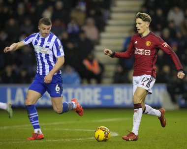 Manchester United takımından Alejandro Garnacho, Wigan Athletic 'in 8 Ocak 202' de Wigan, Wigan 'da Manchester United' a karşı oynanan üçüncü tur karşılaşmasında Wigan Atletizm Ligi 'nden Charlie Hughes' a koşuyor.