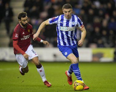 Wigan Athletic takımından Jason Kerr, 8 Ocak 2024 'te Wigan Atletizm Ligi' nde Manchester United 'a karşı oynanan üçüncü tur karşılaşmasında Manchester United takımından Bruno Fernandes' in önünde dönüyor.