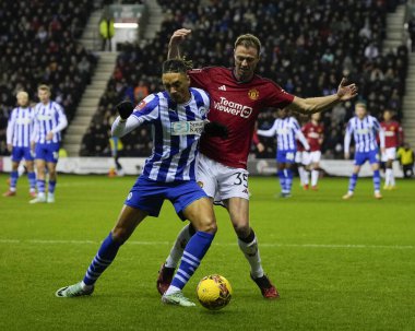 Wigan Athletic 'ten Martial Godo, 8 Ocak 2024 tarihinde İngiltere' nin Wigan şehrinde oynanan Wigan Atletizm Ligi üçüncü tur karşılaşmasında topu Manchester United 'dan Jonny Evans' a karşı koruyor.