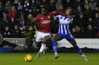 Manchester United 'dan Kobbie Mainoo, Wigan Athletic Martial Godo' yu 8 Ocak 2024 'te Wigan Stadyumu' nda Wigan Atletizm Ligi üçüncü tur karşılaşmasında durdurdu.