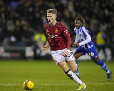 Manchester United takımından Scott McTominay, Wigan Atletizm Ligi 'nden Baba Adeeko' yu 8 Ocak 2024 'te Wigan Atletizm Ligi' nde yendi.