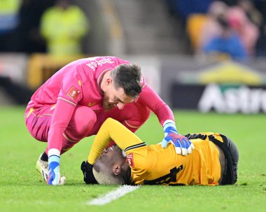 Wolverhampton Wanderers 'dan Jos S, 23 Ocak 2024 tarihinde Wolverhampton, Wolverhampton, Wolverhampton' da oynanan üçüncü tur rövanş karşılaşmasında sakatlanarak yere düşen Wolverhampton Wanderers 'ın Toti Gomes' ı kontrol ediyor.