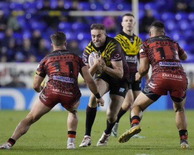 Warrington Wolves 'dan James Harrison, 3 Şubat 2024' te İngiltere 'nin Warrington kentinde oynanan Rugby Ligi Joe Philbin Tanıklık maçı sırasında Leopards takımından Kai ODonnell' da koşuyor.