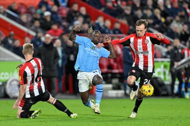 Manchester City 'den Jrmy Doku, Brentford' dan Mikkel Damsgaard ve Brentford 'dan Ben Mee tarafından Premier League karşılaşmasında durduruldu. Brentford Manchester City' ye karşı Gtech Community Stadyumu, Londra, 5 Şubat 2024