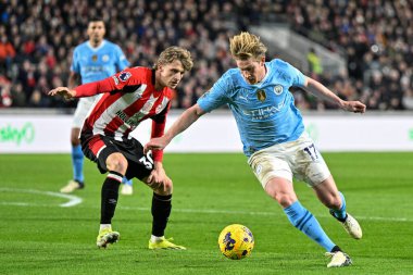 Manchester City 'den Kevin De Bruyne, Brentford' lu Mads Roerslev 'in Premier League maçında Brentford' a karşı Manchester City 'nin 5 Şubat 202' de Londra 'daki Gtech Community Stadyumu' nda oynadığı maçta attığı top ile mola verdi.