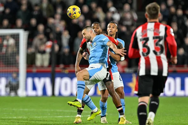 Manchester City 'den Mateo Kovai, Premier League maçında Brentford Manchester City' ye karşı 5 Şubat 2024 'te Londra' daki Gtech Community Stadyumu 'nda yüksek topu kazanmak için atlıyor.