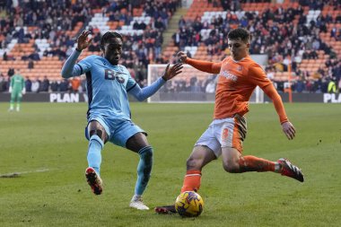 Blackpool 'dan Albie Morgan topu Oxford United takımından Jay Matete' nin baskısıyla Bloomfield Road, Blackpool, İngiltere 'de oynanan 1. Blackpool-Oxford maçı sırasında geçiyor.