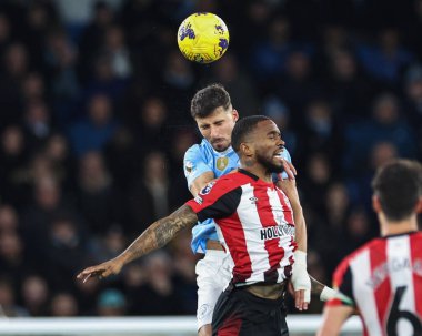 Manchester City 'den Rben Dias, 20 Şubat 2024' te Etihad Stadyumu 'nda oynanan Premier League karşılaşmasında Brentford' lu Ivan Toney 'den yüksek topu almak için sıçradı.