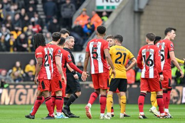 Premier Lig maçında Wolverhampton Wanderers, Sheffield United 'a karşı Molineux, Wolverhampton, Birleşik Krallık' ta 25 Şubat 202 'de oynanan maçta VAR kırmızı kart için hakem Darren Bond' u çevreler.