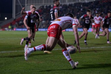 St. Helens takımından Lewis Dodd, Salford Red Devils 'in 8 Mart 202' de St Helens - Salford Red Devils maçında oynanan Betfred Süper Lig 4 'üncü raundda oynanan karşılaşma için savunmasını yarıp geçti.