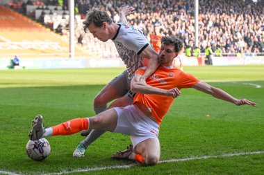 Blackpool 'dan Jake Beesley ve Portsmouth' dan Sean Raggett 9 Mart 2024 'te Bloomfield Road, Blackpool, İngiltere' de oynanan Sky Bet 1 maçı sırasında top için mücadele ettiler.