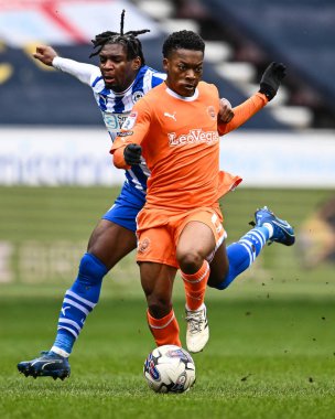 Blackpool takımından Karamoko Dembele, Wigan Athletic takımının 16 Mart 202 'de Wigan, İngiltere' deki Wigan Stadyumu 'nda oynanan Sky Bet 1 karşılaşmasında top ile Baba Adeeko' ya faul yaptı.