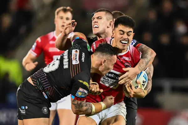 stock image Tim Lafai of Salford Red Devils is tackled by Brad ONeill of Wigan Warriors and Tyler Dupree of Wigan Warriors during the Betfred Super League Round 5 match Salford Red Devils vs Wigan Warriors at Salford Community Stadium, Eccles, United Kingdom