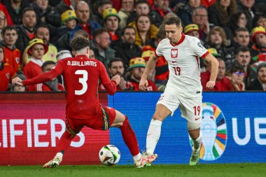 Polonyalı Przemysaw Frankowski, Galler 'den Neco Williams' ın UEFA Euro Eleme Grubu A eleme grubu Galler 'e karşı Polonya maçı sırasında Cardiff City Stadyumu' nda 26 Mart 2024 'te yaptığı baskıyla topu bırakıyor.