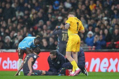 Belçika 'dan Jeremy Doku Manchester City' den takım arkadaşı İngiltere 'den John Stones' u Uluslararası Dostluk maçı sırasında Wembley Stadyumu, Londra, Birleşik Krallık 'ta 26 Mart 202' de oynanan karşılaşmada nakavt olduktan sonra kontrol ediyor.