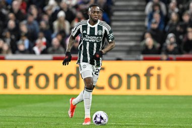 Manchester United takımından Aaron Wan-Bissaka 30 Mart 202 'de Londra' daki Gtech Community Stadyumu 'nda Brentford Manchester United' a karşı oynanan Premier League maçında topu bırakıyor.