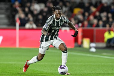 Manchester United takımından Aaron Wan-Bissaka 30 Mart 202 'de Londra' daki Gtech Community Stadyumu 'nda Brentford Manchester United' a karşı oynanan Premier League maçında topu bırakıyor.