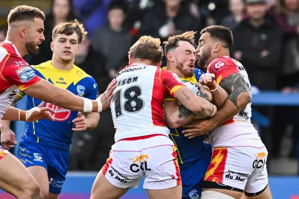 Warrington Wolves 'tan Matty Ashton, Katalan Ejderhaları' ndan Matt Ikuvalu ve Katalan Ejderhaları 'ndan Ugo Tison ile oynadığı Betfred Süper Ligi maçı sırasında Halliwell Jones Stadyumu, Warrington, Birleşik Krallık, 30. 