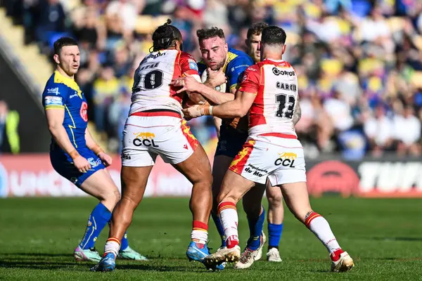 Warrington Wolves 'tan James Harrison, Katalan Ejderhaları' ndan Chris Satae ve Katalan Ejderhaları 'ndan Ben Garcia tarafından Halliwell Jones Stadyumu' nda oynanan Warrington Wolves - Catalans Dragons maçında yenildi.