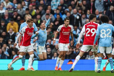 Phil Foden of Manchester City is fouled by Martin degaard of Arsenal during the Premier League match Manchester City vs Arsenal at Etihad Stadium, Manchester, United Kingdom, 31st March 2024 clipart