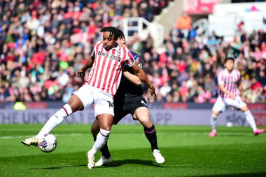 Stoke City 'den Niall Ennis topu Huddersfield Town' dan Matty Pearson 'a karşı kullanıyor. 1 Nisan 202' de Stoke City 'nin Bet365 Stadyumu' nda Huddersfield Town 'a karşı oynadığı Sky Bet maçında.