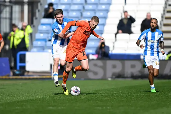 stock image George Saville of Millwall is tackled by Ben Jackson of Huddersfield Townduring the Sky Bet Championship match Huddersfield Town vs Millwall at John Smith's Stadium, Huddersfield, United Kingdom, 6th April 2024