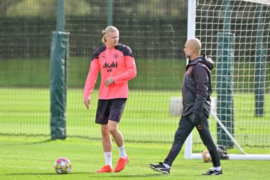 Manchester City 'den Erling Haaland, Manchester City Şampiyonlar Ligi antrenman oturumu öncesinde Manchester City teknik direktörü Pep Guardiola ile konuşuyor.