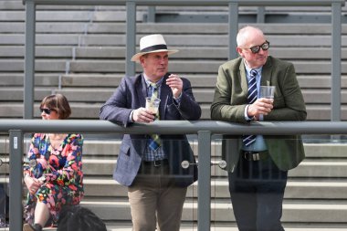 Yarış taraftarları, 11 Nisan 202 'de Aintree Yarış Pisti, Liverpool' daki Randox Grand National 2024 Açılış Günü 'nün önünde tribünlerde pozisyon almaya başladılar.